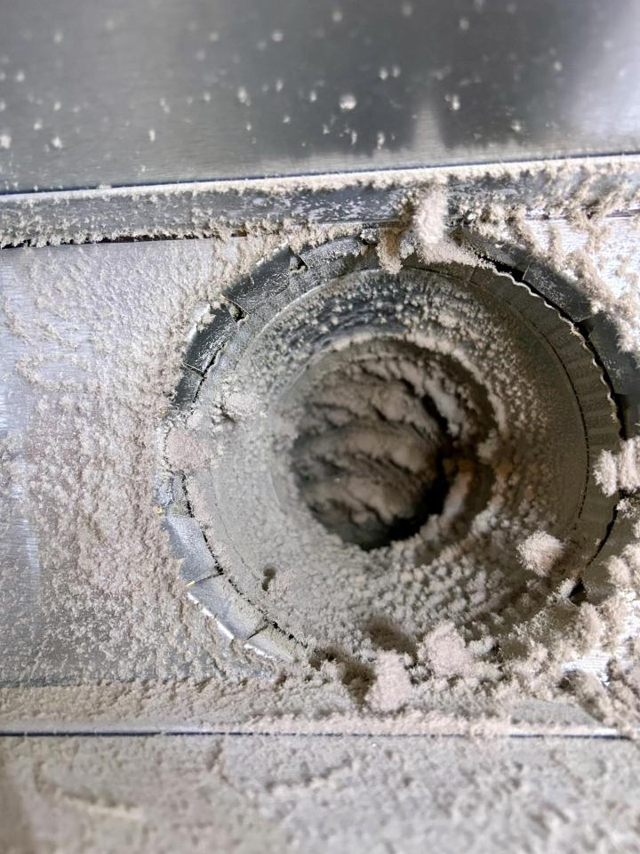 Black grease-coated duct boot interior before commercial air duct cleaning
